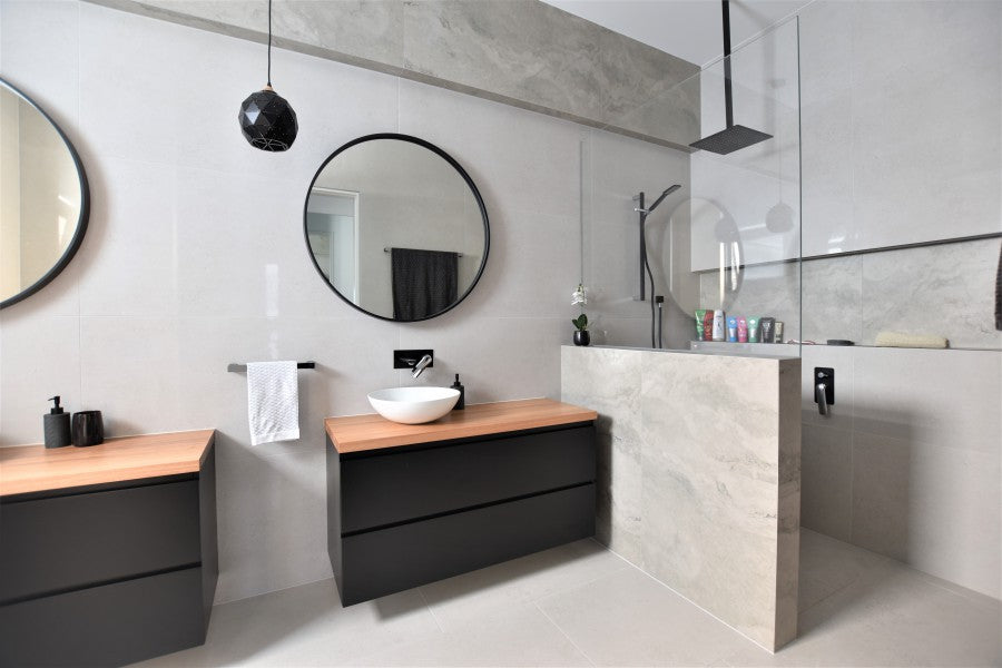 #63 - Bathrooms: Matte black against large format limestone look tiles with travertine feature