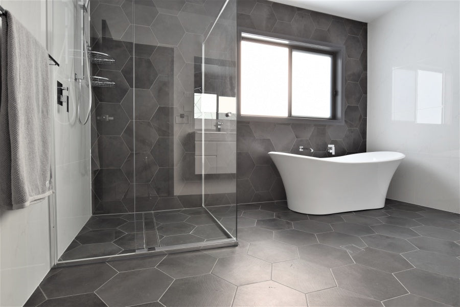 #84 - Bathrooms: Hexagonal charcoal tiles contrast against all-white walls and furniture