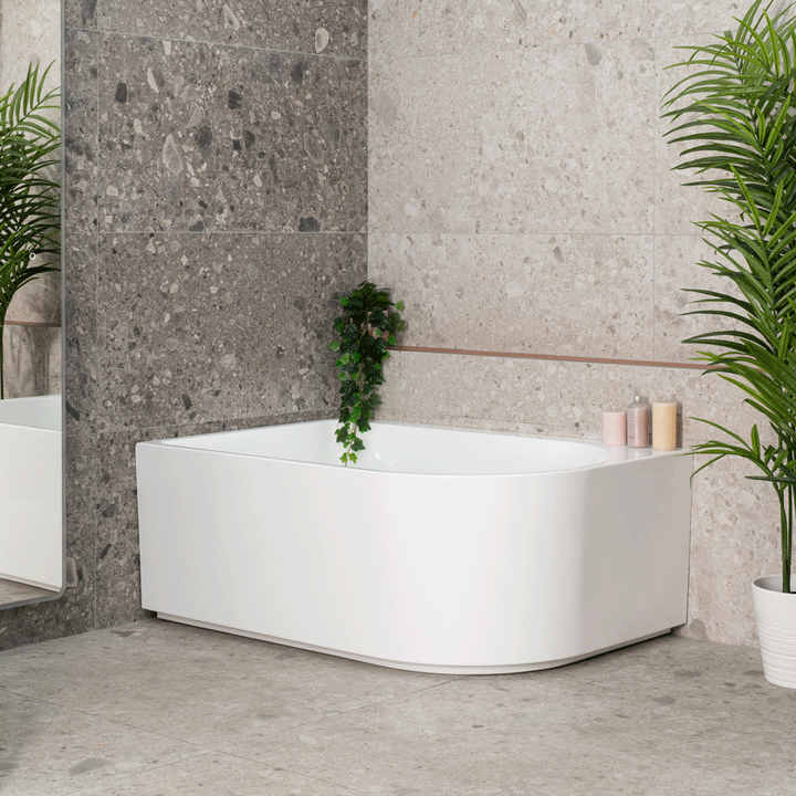 Arco Corner Bathtub with integrated shower screen in a modern bathroom with terrazzo-look tiles and rounded corner design.