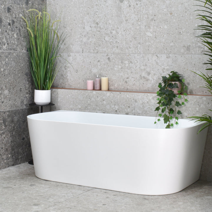 Avalon Freestanding Bathtub in matte white with soft curved edges in a modern bathroom with terrazzo-look wall tiles.