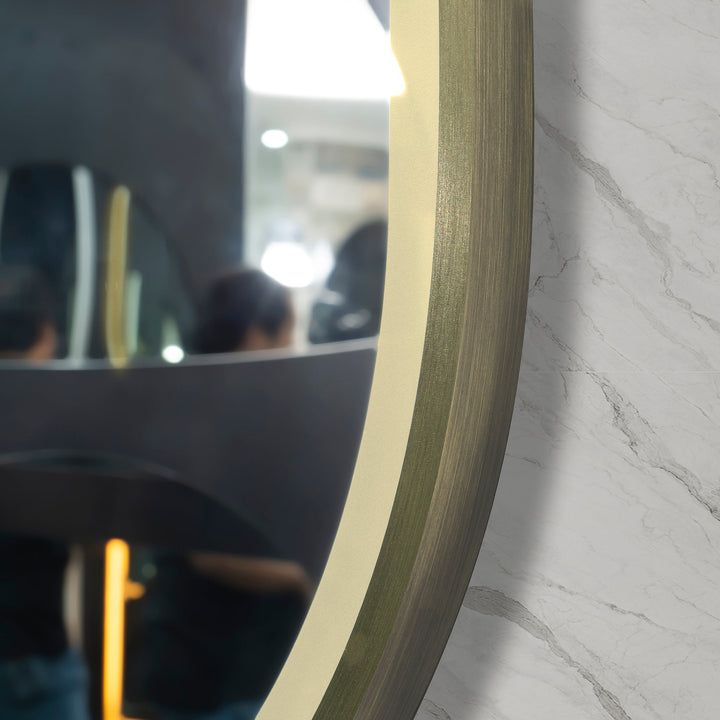 Brushed brass gold framed mirror with detailed texture, angled shot at the right lower side.