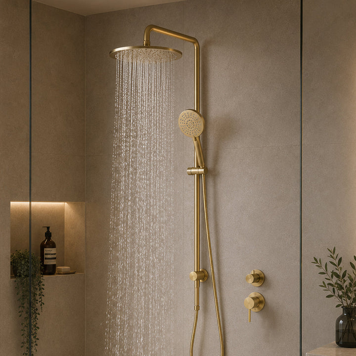 Premium bathroom with brushed brass twin shower system, round mixer, rainfall shower head and running water in modern spa-style design