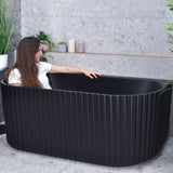 Agora Groove 1500mm back to wall bathtub in matte black, angled view with model